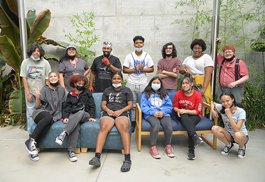 group of students in masks sitting on couch
