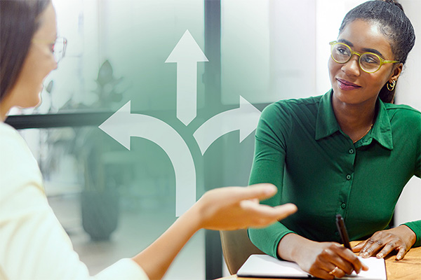 a career coach advises another person while sitting at a table