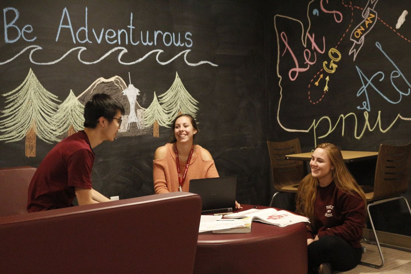 three students talk in circle inside residence hall