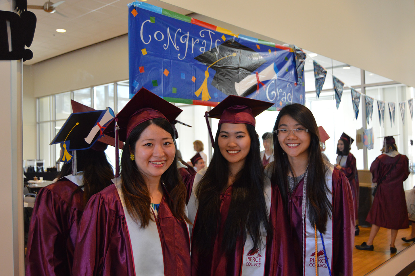 three students at graduation ceremony