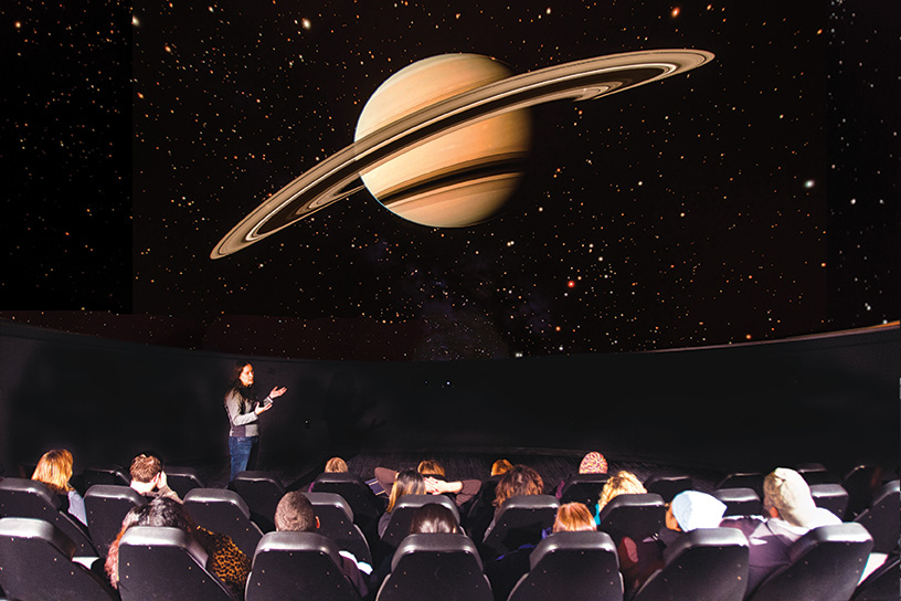 person giving a space presentation inside planetarium