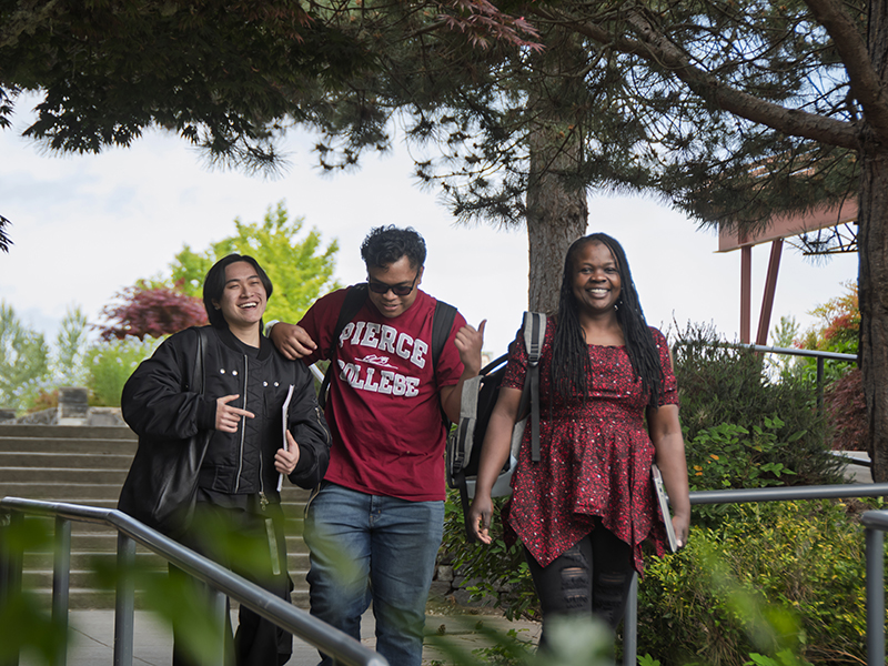 three students walking outdoors on campus