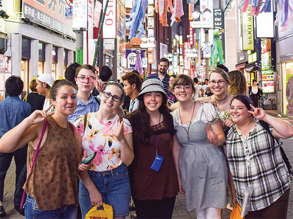 group of students poses on busy city street