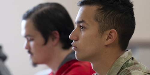 student in military uniform stares forward in class