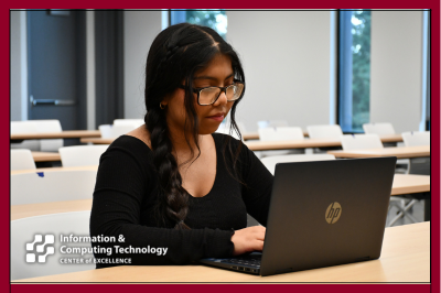 student in classroom on laptop