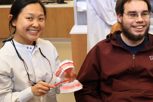 dental hygiene student demonstrating proper brushing techniques