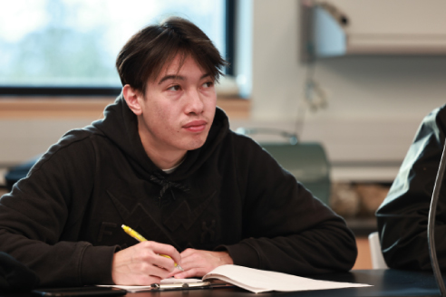 student at desk writing on paper