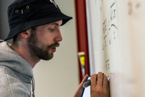 student solving math problem on whiteboard