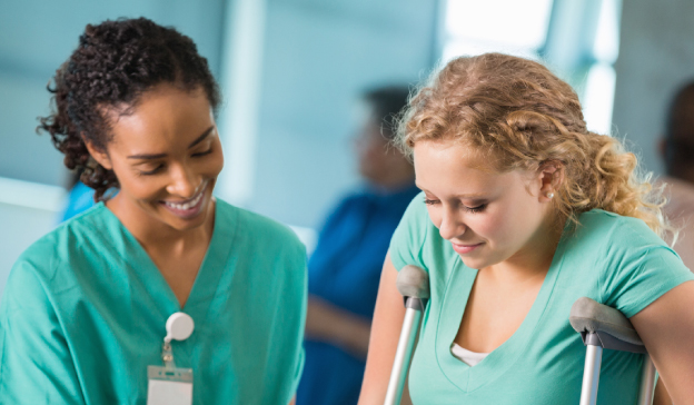 healthcare worker assisting woman on crutches