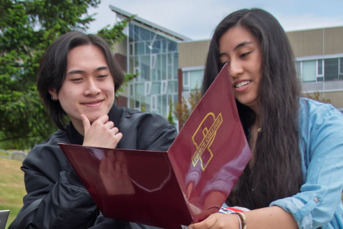 Two students collaborating outside on campus