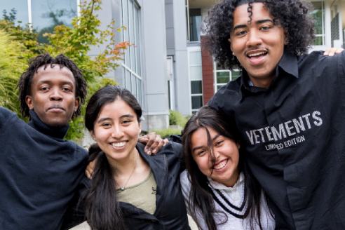 A group of four students celebrating outdoors