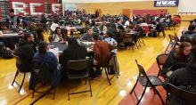 group photo of aspire summit attendees seated at tables in a gymnasium