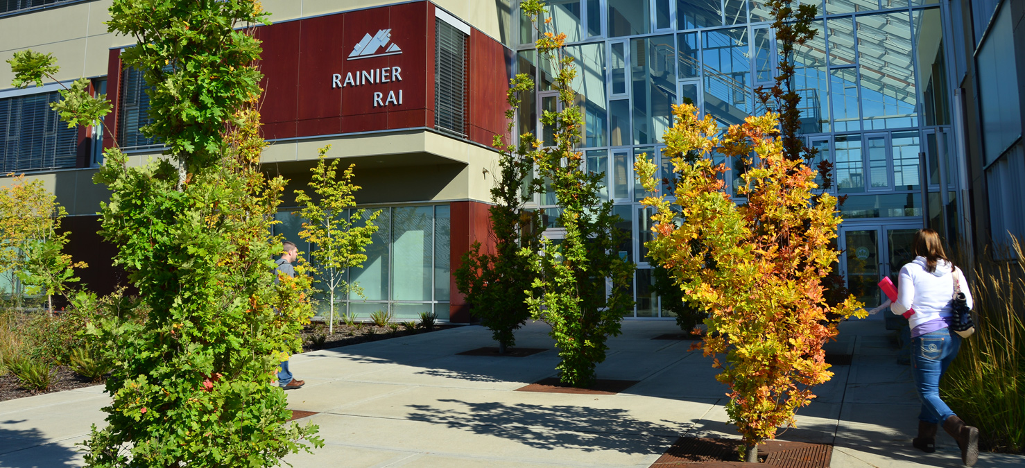 student entering rainier building and fall foliage