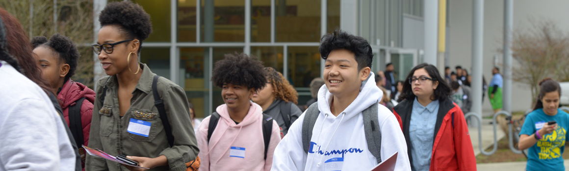 group of students wearing nametags walking outdoors on campus