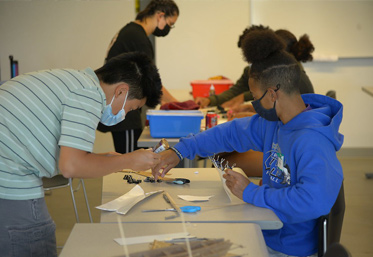 students wearing masks working on construction project at desk