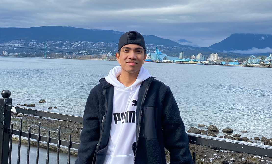 anton dang standing in front of a city harbor