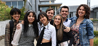 seven students from The Pinnacle stand in front of the Cascade building on the Pierce College Fort Steilacoom campus