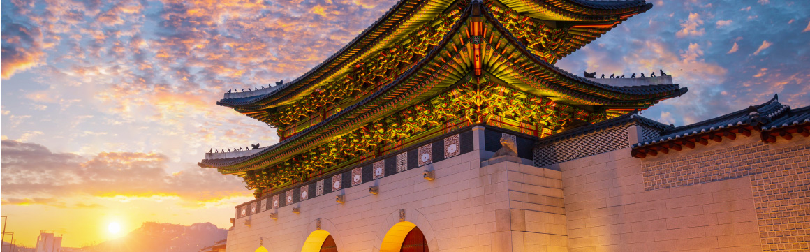 sun setting behind temple in seoul, south korea