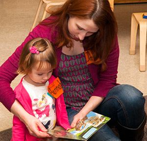 woman reading a book to a young girl