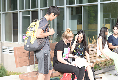 students sitting on bench on fort steilacoom campus