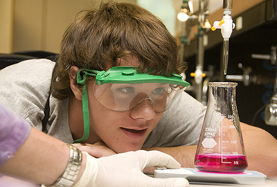 student looking at beaker in science class