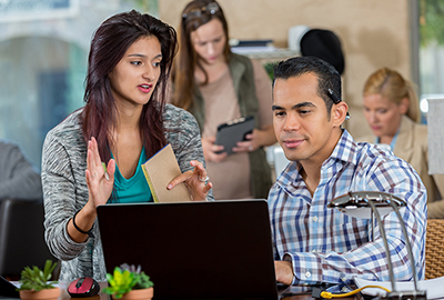 instructor assisting student at a computer