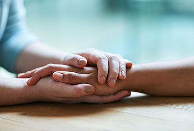 Counselor holding client's hands