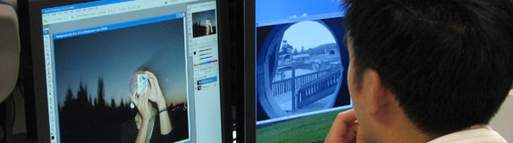 student working on two computer monitors