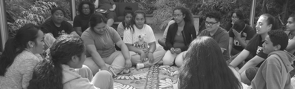 asian american and pacific islander students sitting in a circle on a blanket