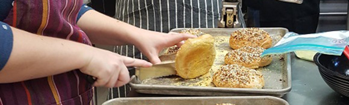 community and continuing education cutting a bagel in class