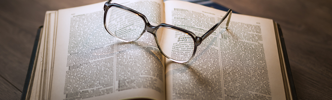 eyeglasses perched on top of open book