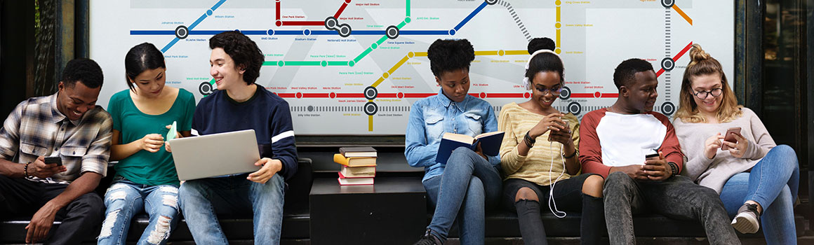 people sitting on a bench at a bus stop, with a transit map on the wall behind them