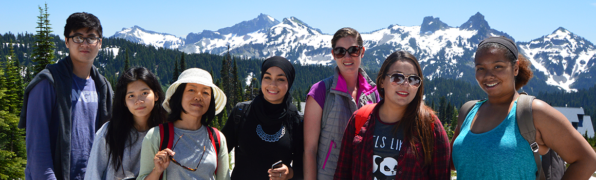 students with hiking gear outside with mount rainier in the background students with hiking gear outside with mount rainier in the background