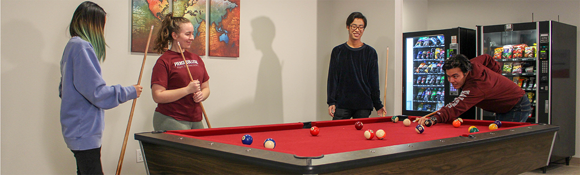 students playing pool in the residence hall students playing pool in the residence hall