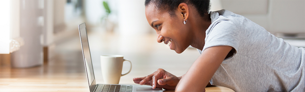 Woman using laptop while lying on the floor