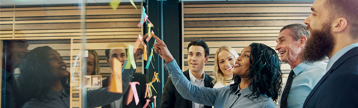 woman pointing at a board covered in notes