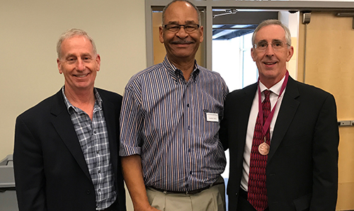 foundation presidents board president jeff brown and incoming president jonathan harris, presenting board member mike smith with an award