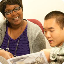 instructor and student in military uniform looking at brochure together