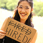 Fired to hired person holding sign that has the word fired crossed out and the word hired replacing it
