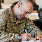 Military student studying with a smile