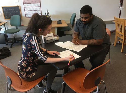 student and tutor working together at table in puyallup writing center student and tutor working together at table in puyallup writing center